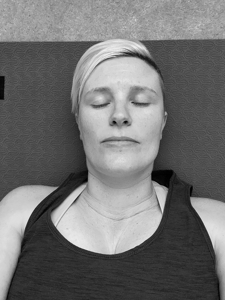 photo of me laying on yoga mat with eyes closed